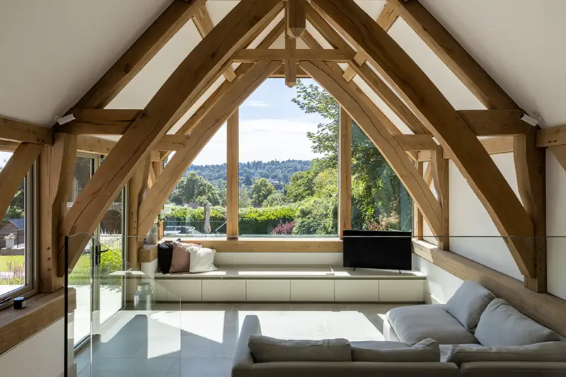 Sofa in front of triangular window with oak frame